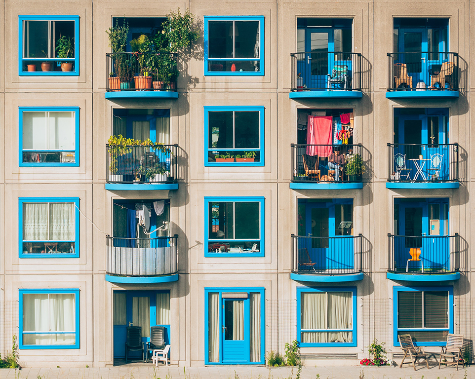 Wohnblock mit blau gerahmten Fenstern und Balkonen